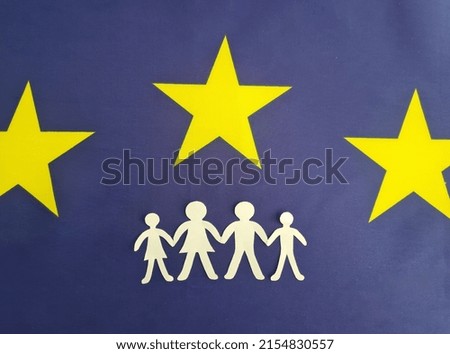 European Union flag with family figurines. Obtaining residence permit In Europe and refugees. European families and insurance