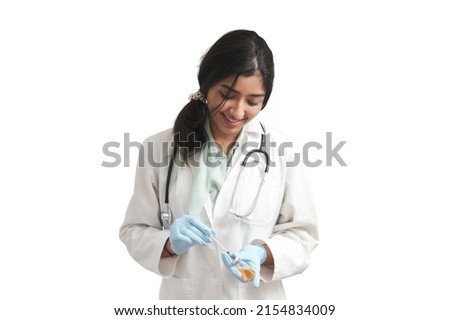 Young Venezuelan female doctor preparing a dose of a vaccine. Isolated over white background.