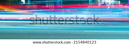 long exposure tracer cars lights. blue and red color lines from vehicles headlights. blurred fast moving transport. night city road traffic. abstract vibrant color dark time city life wide picture. Royalty-Free Stock Photo #2154840123