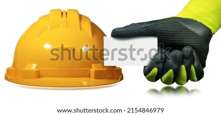 Closeup of an orange and yellow work helmet and a manual worker with green and black protective work gloves holding a blank business card with copy space. Isolated on white background. 