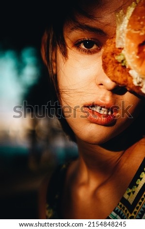 
Beautiful girl with a burger, cinematic toning.