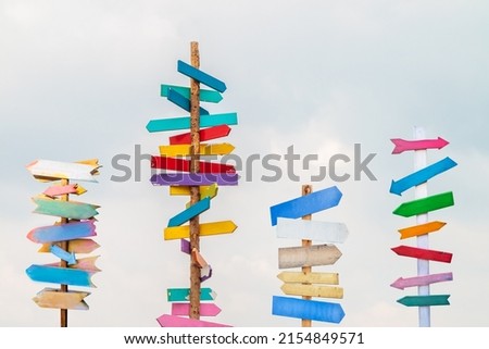 Colorful wooden direction arrow signs on wooden poles Royalty-Free Stock Photo #2154849571