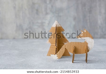 Handmade cardboard fox and fir tree on grunge background