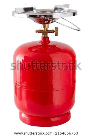 Portable gas bottle. A small compact travel bottle with a burner for cooking on a hike. The road gas stove is filled with propane. Red tank. Royalty-Free Stock Photo #2154856753