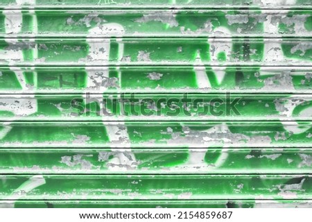 Green metal shutter with peeling paint. Ideal use for background  wallpaper.