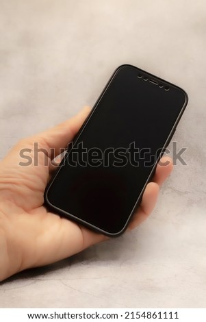 handheld mobile phone on gray background for telecommunication and technology