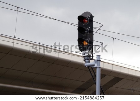 Railroad signals pole, railway signal lights for trains and suspended overhead electric power train lines cables.