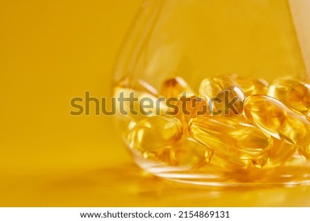 Omega-3 fatty acid capsules on a blue background in a flask. The concept of medicine and healthy living. Front view.
