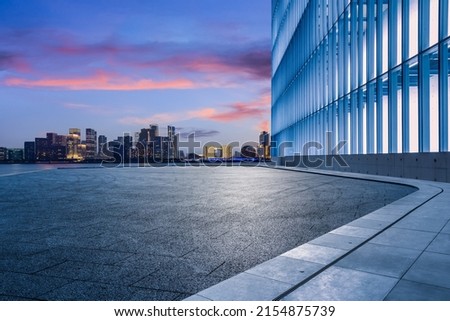 Empty square floor and city skyline with modern commercial buildings in Hangzhou at sunrise, China.