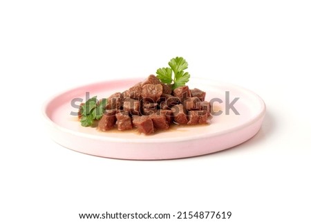 Delicious wet food for a cat or dog, pieces of nutritious meat for an animal, dog or cat in a plate on a white background. Royalty-Free Stock Photo #2154877619
