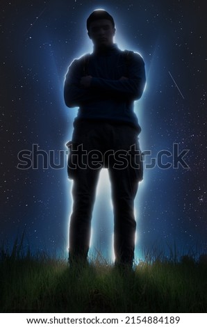 Silhouette of a man with a white border against the background of stars. Front view from below.