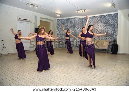 A group of beautiful girls in a choreography studio for training dancing in oriental outfits Royalty-Free Stock Photo #2154886843