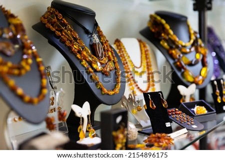 Collection of natural amber jewelry displayed for sale on shelves of boutique.. Royalty-Free Stock Photo #2154896175