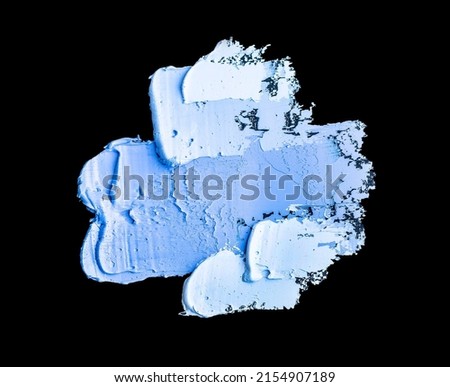 Spots of blue and white oil paint isolated on black background.