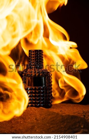 Perfume fire bottle. Mockup on the dark or black empty background.