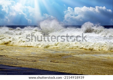 Heavy violent dramatic surf waves crashing on secluded black lava sand beach, misty sea spray foam, sun backlight rays clouds - Cobquecura Piedra De La Loberia, Chile, Pacific ocean