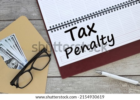 TAX PENALTY. Business concept. text on planner page near envelope and glasses