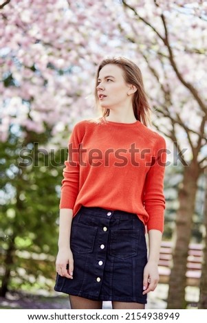 Young beautiful woman. Cottagecore aesthetics, sustainable, nature concept. Connecting with nature, self-discovery. Pink sakura flower tree. Japanese sakura is a traditional symbol of female youth