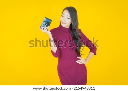 Portrait beautiful young asian woman use camera on color background