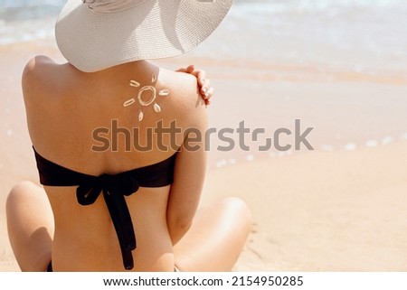 Woman apply sun cream protection on tanned shoulder. Beauty skincare aging body care.