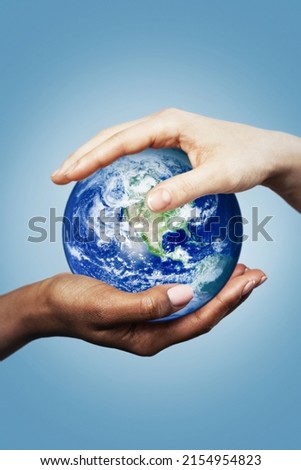 African and Caucasian female hands holding earth globe. Different concept such as ecology, international friendship and equality. Elements of this image furnished by NASA. Royalty-Free Stock Photo #2154954823