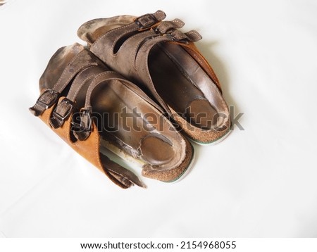Completely worn out and broken pair of leather cork therapeutic slippers for flat foot Royalty-Free Stock Photo #2154968055