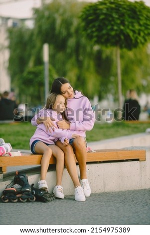 Mother and daughter rest after rollerskating at park