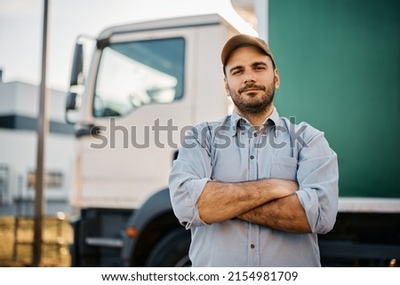 Portrait of confident truck driver on parking lot looking at camera. Copy space. Royalty-Free Stock Photo #2154981709