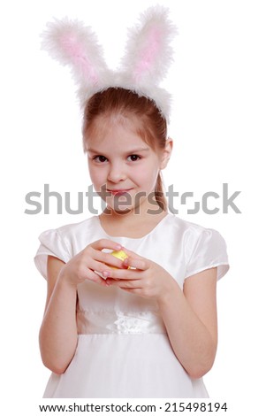 Smiley little girl dressed in Easter bunny ears holding colorful eggs
