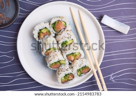 California roll with avocado and salmon in the table with chopsticks