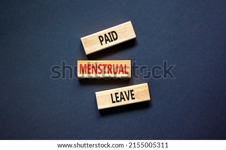 Paid menstrual leave symbol. Concept words Paid menstrual leave on wooden blocks. Beautiful black table black background. Business medical paid menstrual leave concept. Copy space.