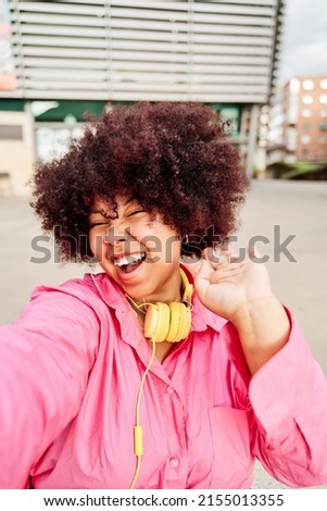 african american woman with curly hair taking a selfie with a tablet pc. young woman waving while making a video call.