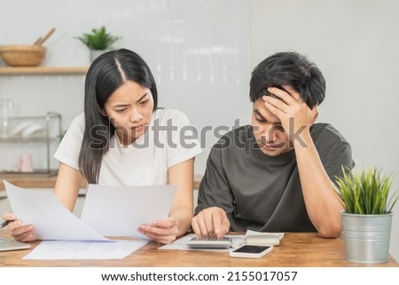 Stressed asian young couple family, wife and husband confused by calculate expense from invoice or bill, have no money to pay. Mortgage, loan causing debt, bankruptcy. Debt problems, Financial people. Royalty-Free Stock Photo #2155017057