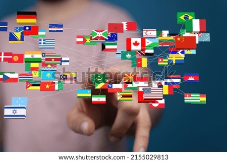 A blurred man clicks on international flags 3d global concept of the partners and travels around the world