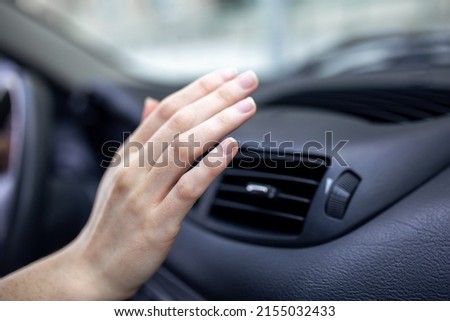 woman adjusting the cooling inside her car, Closeup of hand driver checking adjusting air from conditioning the cooling system with flow of cold air in car.