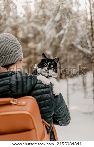 A guy with his black and white cat and a cat hiking backpack in Fredericton, New Brunswick, Canada