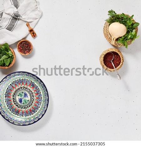 Oriental food background with empty uzbek plate and spices. Eastern cuisine background with copy space. Flat lay in eastern style with traditional dishes and fresh herbs. Uzbek food menu Royalty-Free Stock Photo #2155037305