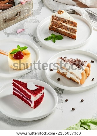 Composition with assorted cakes. Set of dessert: cheesecake, red velvet, tiramisu, carrot cake. Popular dessert in aesthetic composition. Pieces of cakes: red velvet, tiramisu, cheesecake, carrot cake Royalty-Free Stock Photo #2155037363