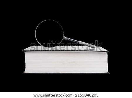 Book with magnifying glass on black background. Information retrieval. Preparing for research project. High quality photo