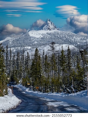 Lenticular clouds over snow covered Three Fingered Jack mountain and access road to Hoodoo ski area in the central Oregon cascade mountains