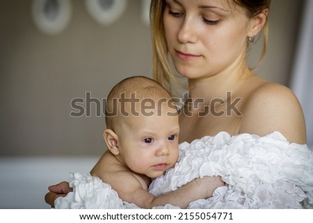 Young woman holding baby boy. Image with selective focus