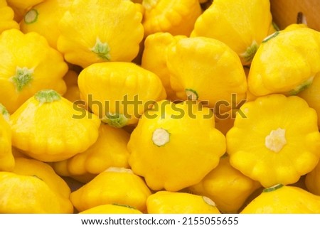 Above view of yellow pattypan summer squash piled for sale at Farmer's Market. Royalty-Free Stock Photo #2155055655