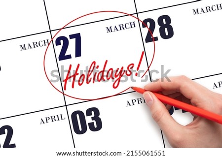 27th day of March. Hand drawing a red circle and writing the text Holidays on the calendar date 27 March. Important date. Spring month, day of the year concept.