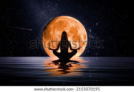 Woman meditating in front of the moon Royalty-Free Stock Photo #2155070195