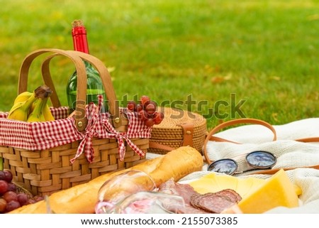 Picnic, camping basket, wine, glasses and fruits, family picnic background with space. Summer and mood. Weekend and vacation, sunny mood