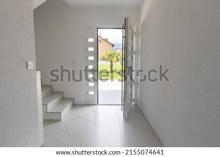 White opened entrance door and marble tiled floor in front of green lawn with palm tree Royalty-Free Stock Photo #2155074641