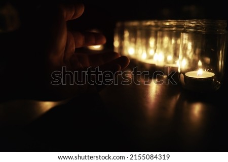 Background with candles in glass. Candles burn in a dark place. Rest in peace.