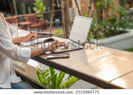 attractive  owner of big company,Portrait of business woman outdoor with coffee and laptop, smiling businesswoman using laptop computer and talking with cellphone, hand with pencil writing on notebook Royalty-Free Stock Photo #2155084775