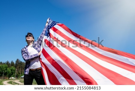 proud strong american man waving USA united state flag against blue sky. Happy Memorial Day	
