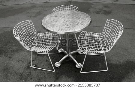 Table and two chairs outside in the rain